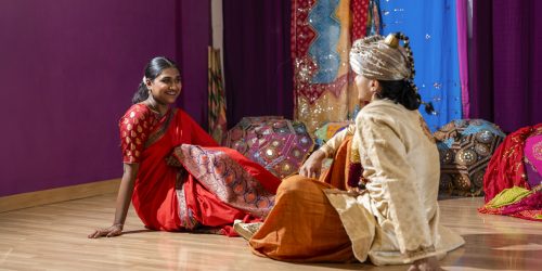 happy indian couple in traditional clothes wedding event sitting on the floor Diplomado en producción de eventos culturales